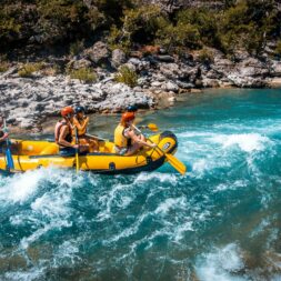 une rivière turquoise, un guide de rafting, 4 adultes avec des pagaies simples