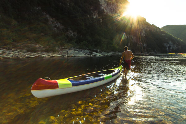 Un homme tire un canoë sur l'Ardèche