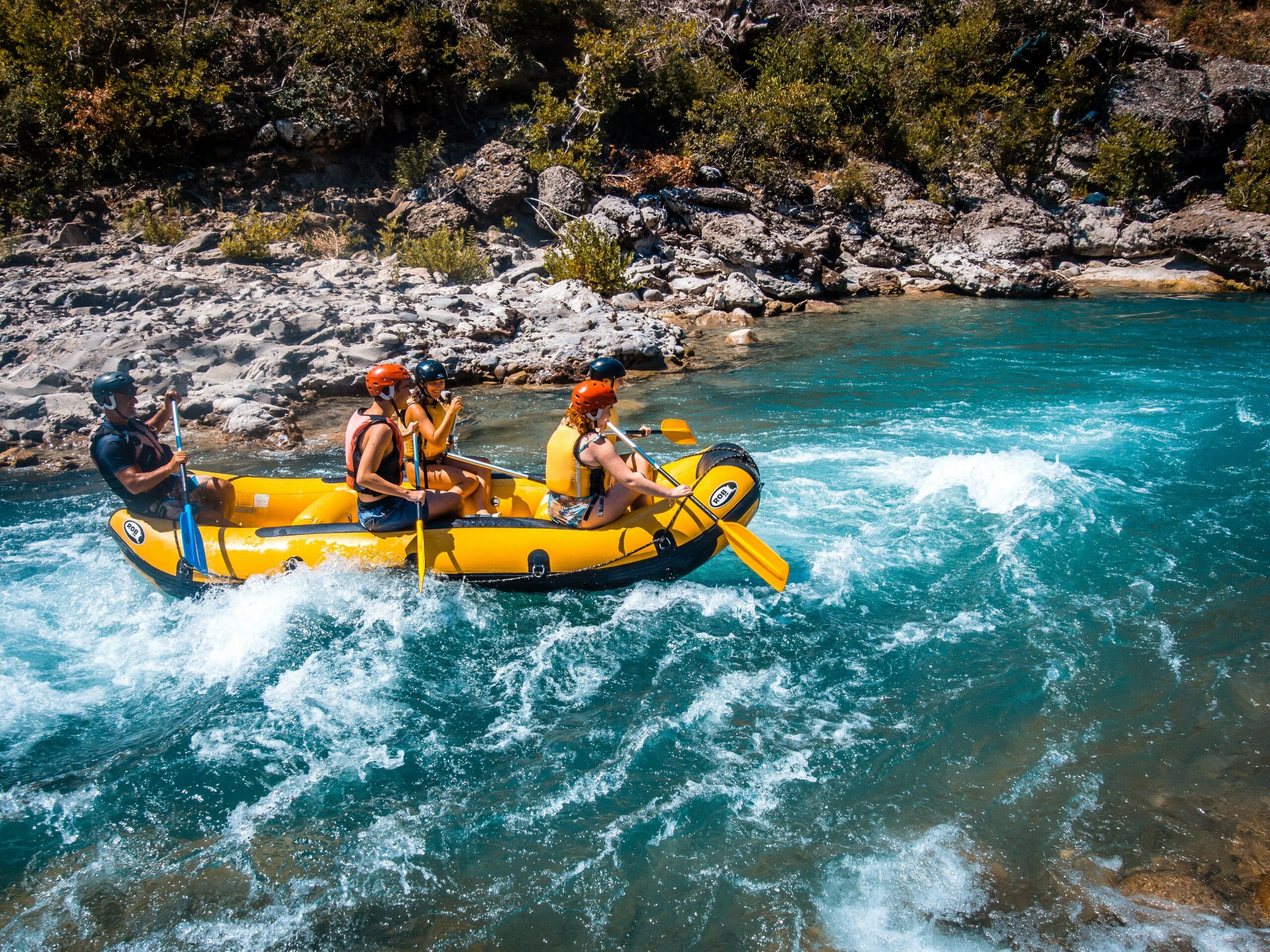 une rivière turquoise, un guide de rafting, 4 adultes avec des pagaies simples