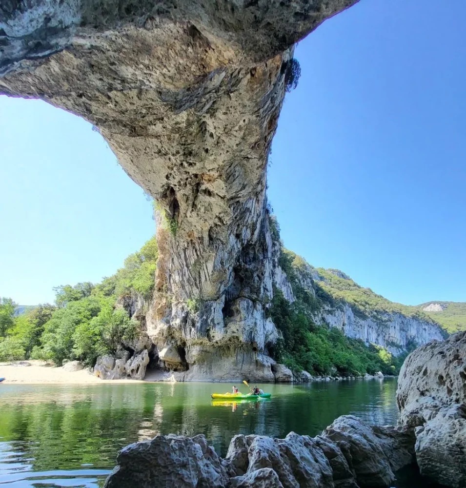 Bateau jaune et vert sous le pont d'arc tout seul
